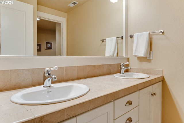 full bathroom with visible vents, a sink, and double vanity