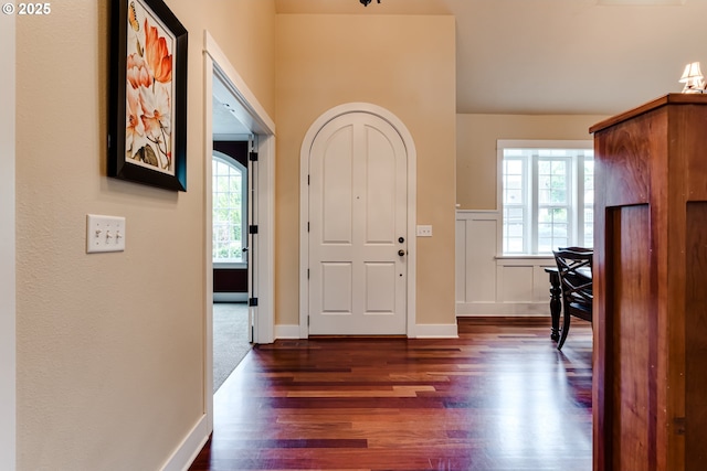 entrance foyer with dark wood-style flooring and baseboards