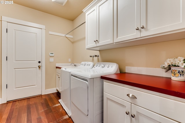 laundry area featuring independent washer and dryer, baseboards, dark wood finished floors, and cabinet space