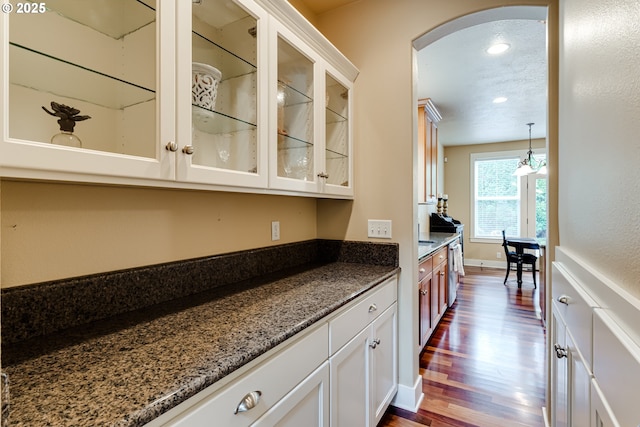 bar featuring recessed lighting, arched walkways, baseboards, and dark wood finished floors