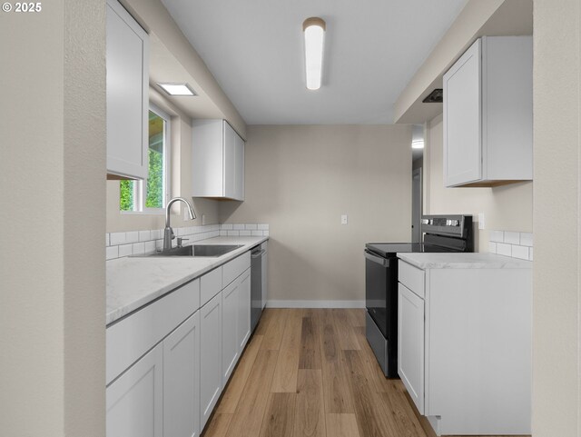 24033 SE Oak St, Gresham, OR 97030 - kitchen featuring electric stove, a sink, stainless steel dishwasher, light wood-style flooring, and white cabinetry