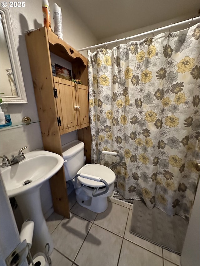 bathroom featuring a shower with shower curtain, tile patterned floors, toilet, and visible vents