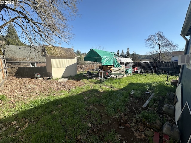 view of yard with an outbuilding, a fenced backyard, and a shed