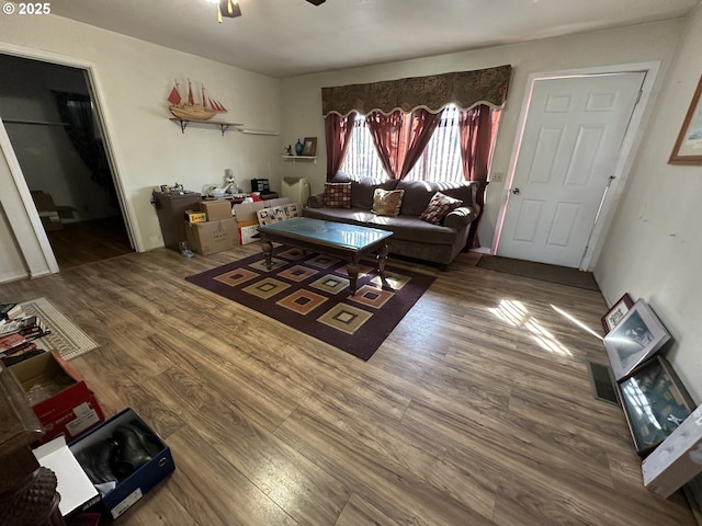 living room featuring visible vents, wood finished floors, and a ceiling fan