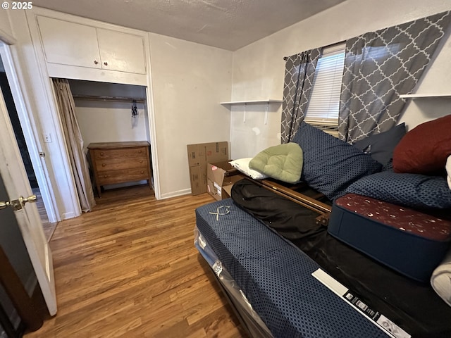 bedroom with a closet, a textured ceiling, and wood finished floors