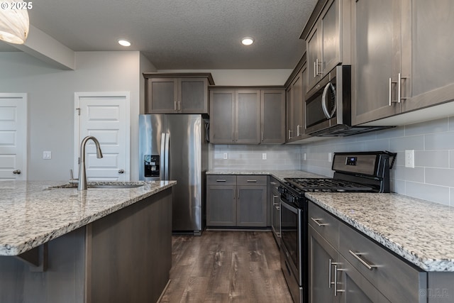 46 Shore Dr, Saint Helens, OR 97051 - kitchen with a sink, stainless steel appliances, dark wood finished floors, backsplash, and light stone countertops