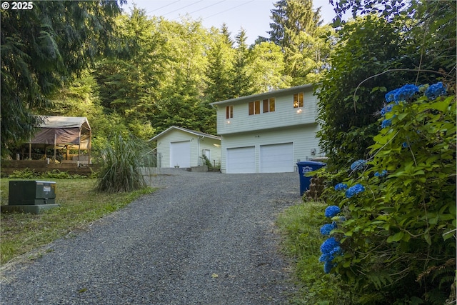 594 NE Newport Heights Dr, Newport, OR 97365 - view of front of home with gravel driveway, an outdoor structure, and a garage