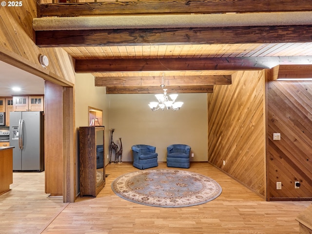 living area featuring wood ceiling, beamed ceiling, wood walls, and light hardwood / wood-style flooring