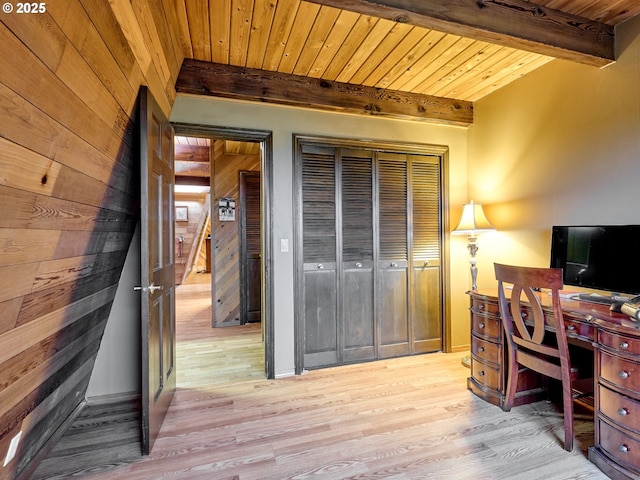 home office featuring light hardwood / wood-style flooring, wooden ceiling, beam ceiling, and wood walls