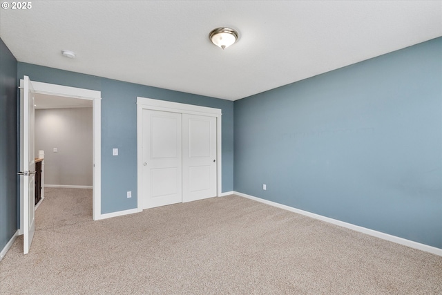 unfurnished bedroom with carpet, baseboards, and a closet