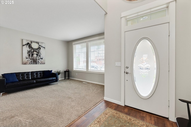 foyer with baseboards and wood finished floors