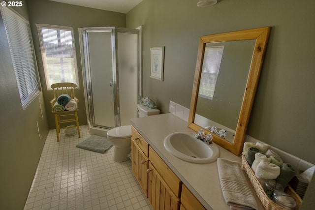 full bath featuring a stall shower, vanity, toilet, and tile patterned floors