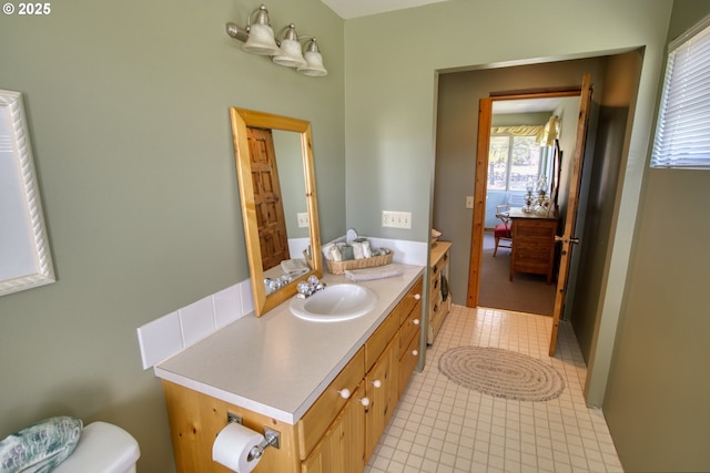 half bath featuring vanity and toilet