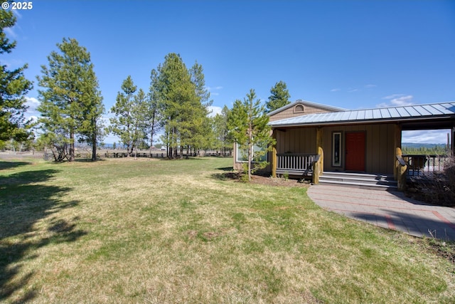 view of grassy yard featuring covered porch