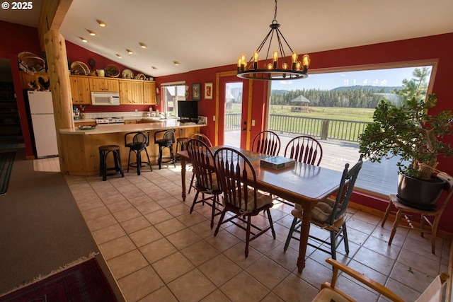 dining room featuring vaulted ceiling, light tile patterned flooring, a chandelier, and recessed lighting