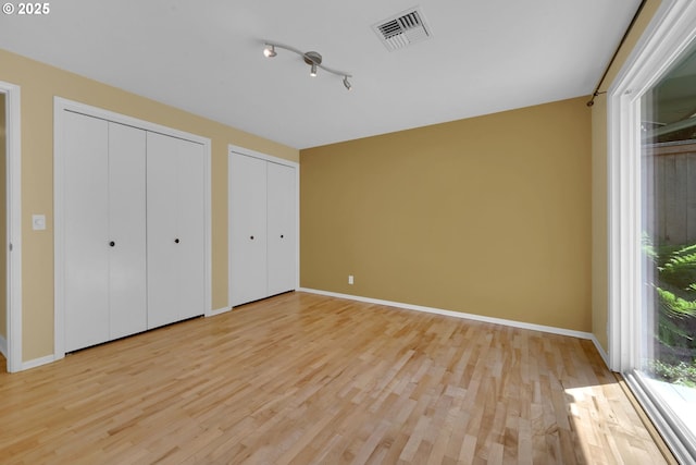 2720 Taylor St, Eugene, OR 97405 - unfurnished bedroom with two closets, baseboards, visible vents, and light wood finished floors