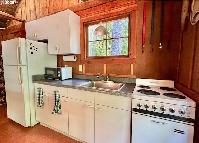 26015 NE Lucia Falls Rd, Yacolt, WA 98675 - kitchen featuring white appliances, dark countertops, white cabinetry, hanging light fixtures, and wood walls