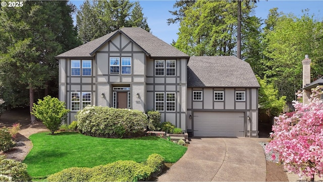 tudor house with stucco siding, a shingled roof, driveway, and an attached garage