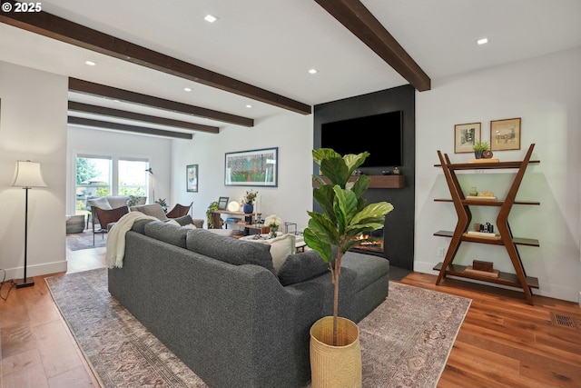 living room with beamed ceiling, wood finished floors, recessed lighting, and baseboards