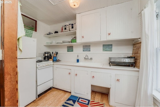 kitchen featuring white appliances, a sink, light countertops, light wood-type flooring, and tasteful backsplash