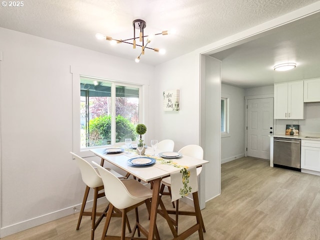 4145 SE Grant St, Portland, OR 97214 - dining area with a chandelier, light wood-style floors, baseboards, plenty of natural light, and a textured ceiling