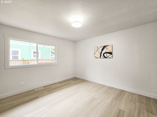 4145 SE Grant St, Portland, OR 97214 - spare room with light wood-type flooring, a textured ceiling, and baseboards