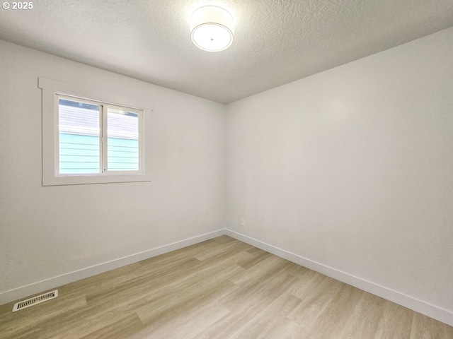 4145 SE Grant St, Portland, OR 97214 - unfurnished room featuring light wood-style floors, a textured ceiling, and baseboards