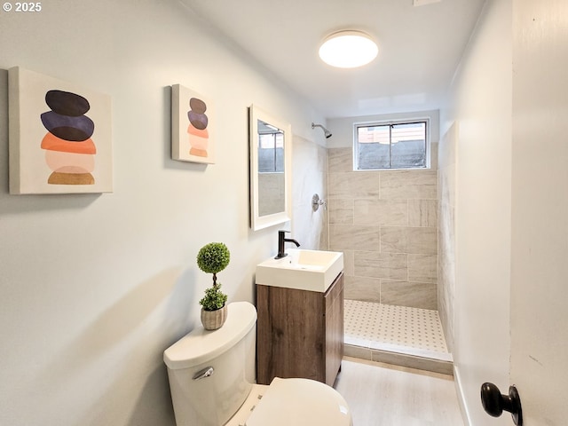 4145 SE Grant St, Portland, OR 97214 - full bathroom featuring toilet, tiled shower, vanity, and wood finished floors