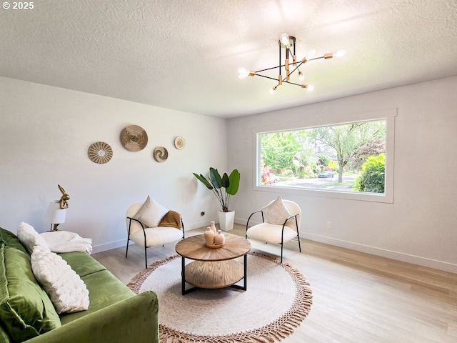4145 SE Grant St, Portland, OR 97214 - living area featuring light wood-style floors, a chandelier, a textured ceiling, and baseboards