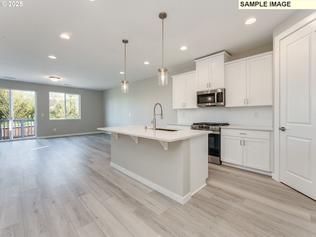 908 NW 178th Way, Ridgefield, WA 98642 - kitchen featuring stainless steel appliances, a sink, open floor plan, backsplash, and light countertops
