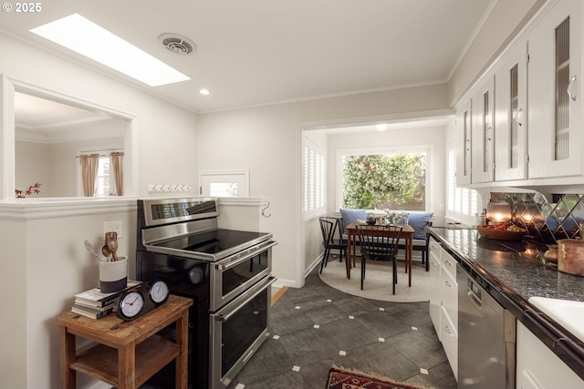6416 NE 23rd Ave, Portland, OR 97211 - kitchen featuring appliances with stainless steel finishes, white cabinets, recessed lighting, ornamental molding, and dark countertops