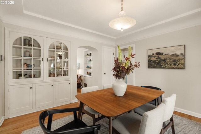6416 NE 23rd Ave, Portland, OR 97211 - dining space with light wood-type flooring, a tray ceiling, arched walkways, and built in shelves