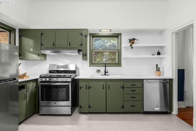 kitchen with stainless steel appliances, sink, decorative backsplash, and green cabinetry