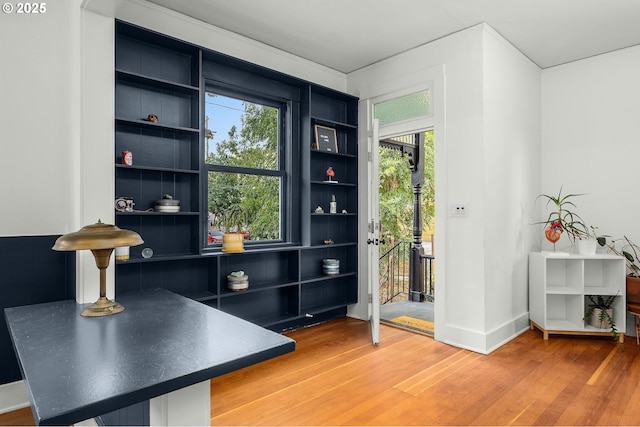 interior space with built in shelves and wood-type flooring