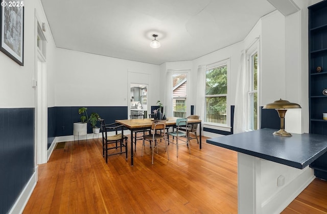 dining space with hardwood / wood-style flooring and built in shelves