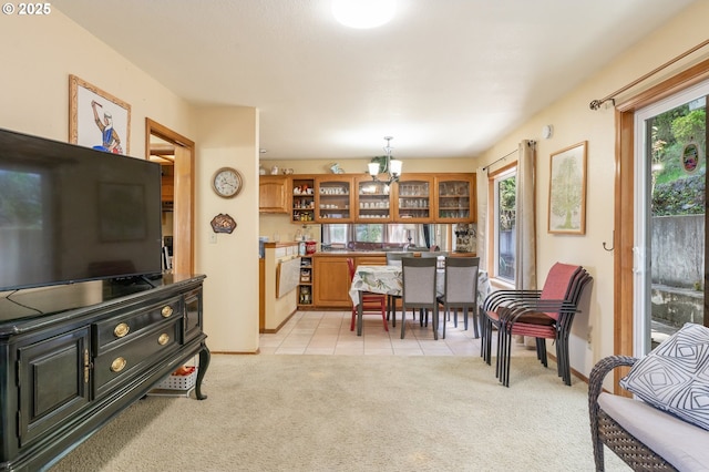 interior space with an inviting chandelier, baseboards, light colored carpet, and a healthy amount of sunlight