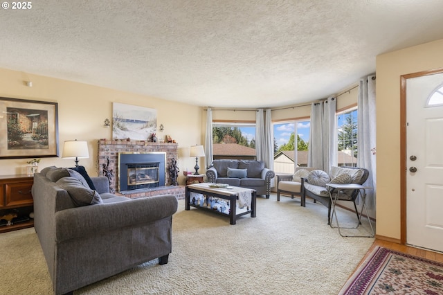 living room with a brick fireplace, a textured ceiling, and plenty of natural light