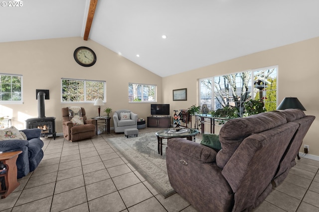 living room with beamed ceiling, high vaulted ceiling, a wood stove, and light tile patterned floors