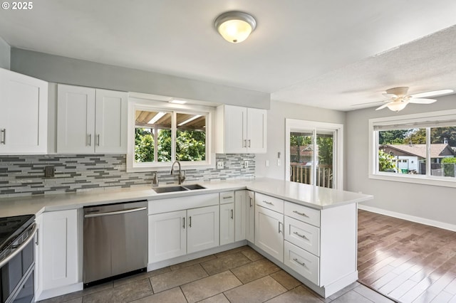 704 SE 207th Ave, Gresham, OR 97030 - kitchen with stainless steel appliances, a peninsula, backsplash, light countertops, and white cabinetry