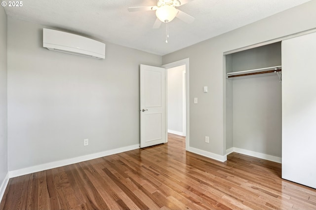 704 SE 207th Ave, Gresham, OR 97030 - unfurnished bedroom with a wall mounted AC, wood finished floors, a closet, and a ceiling fan