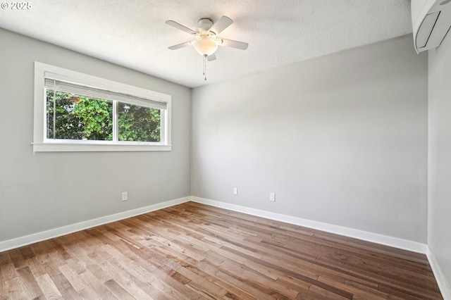 704 SE 207th Ave, Gresham, OR 97030 - spare room with wood finished floors, a ceiling fan, a wall mounted air conditioner, and a textured ceiling