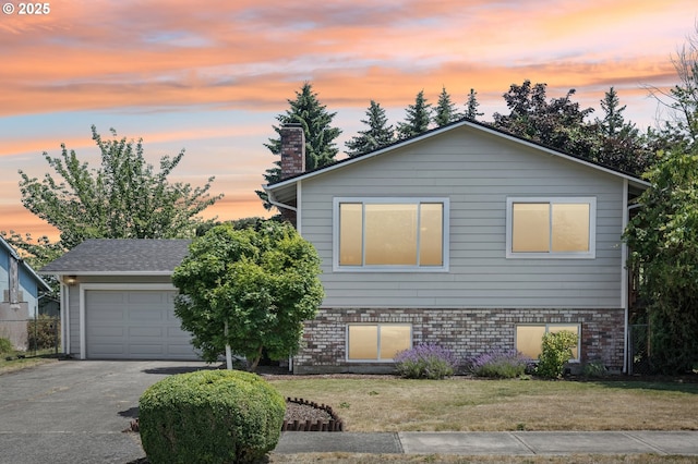 704 SE 207th Ave, Gresham, OR 97030 - view of front of house with driveway, a yard, a garage, a chimney, and brick siding