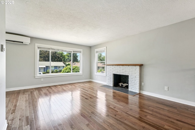 704 SE 207th Ave, Gresham, OR 97030 - unfurnished living room featuring an AC wall unit, a textured ceiling, wood finished floors, and a brick fireplace