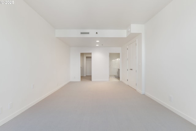 empty room featuring recessed lighting, light colored carpet, visible vents, and baseboards