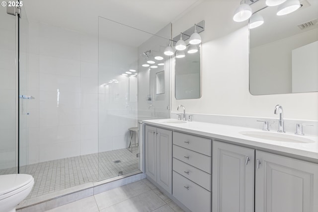 bathroom with toilet, a stall shower, a sink, and visible vents