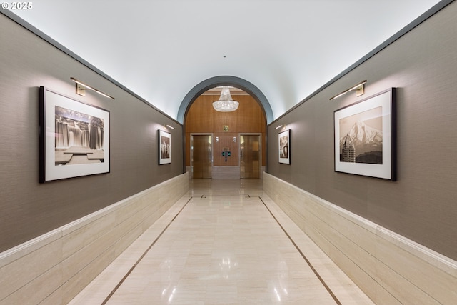 corridor with lofted ceiling and arched walkways