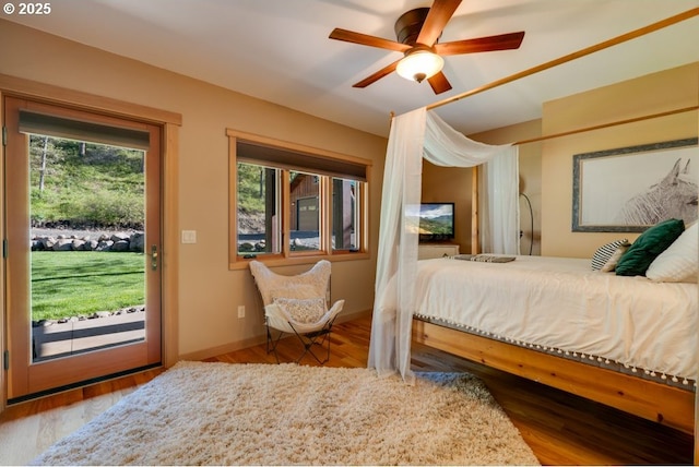 bedroom featuring multiple windows, access to outside, light hardwood / wood-style floors, and ceiling fan