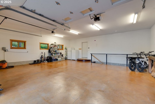 garage featuring white refrigerator and a garage door opener