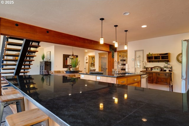 kitchen featuring a large island, sink, decorative light fixtures, and a kitchen bar