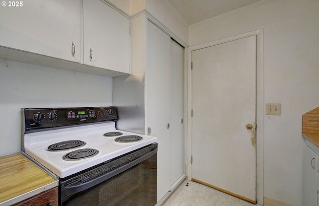 kitchen featuring light floors, white cabinetry, range with electric cooktop, and light countertops